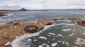 Aerial view over Skútustaðagígar pseudo craters in Mývatn near Reykjahlíð, Iceland, with frozen lake patches, volcanic shapes, and a surreal Arctic landscape under soft winter light. - Powered by Shutterstock - Get 15% off with code: PIKWIZARD15