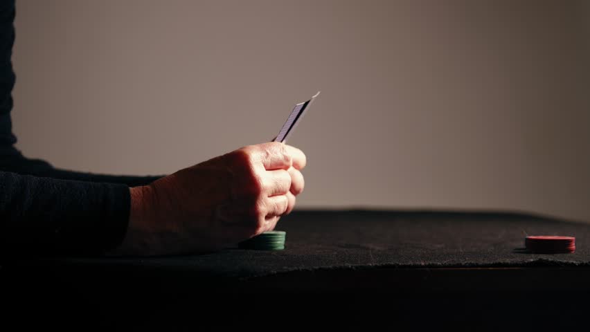 Poker player looking at cards in a game medium 4k shot selective focus