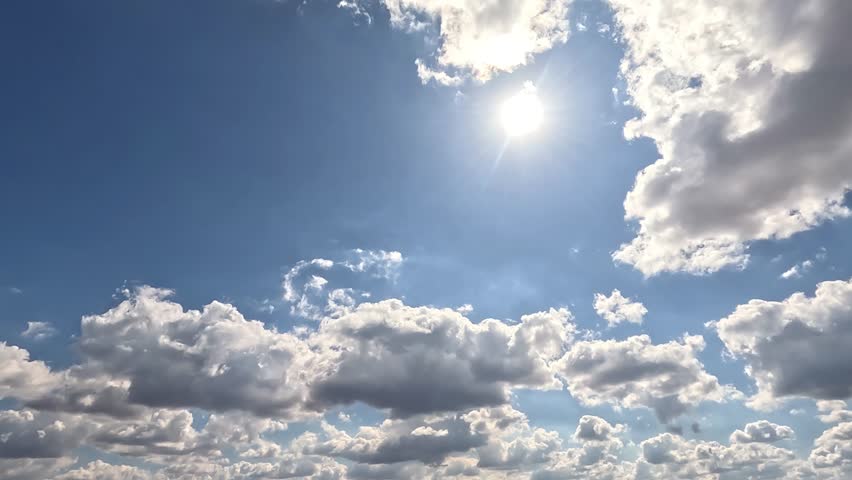 Flowing Endless Clouds in the Daylight Skies. 4K video (Ultra High Definition) of cloudscape and bright sun. Sky and clouds Timelapse. Sun shines through the clouds on the dramatic sky background.