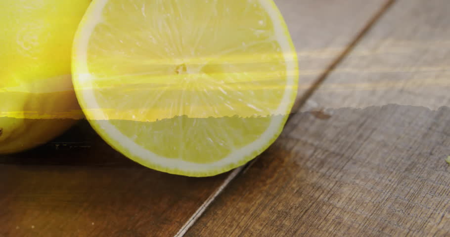 Starting closeup halved lemon slice, light streaks drifting camera zooming out revealing two lemons. Citrus, freshness, natural, rustic, bright, minimalism, healthy