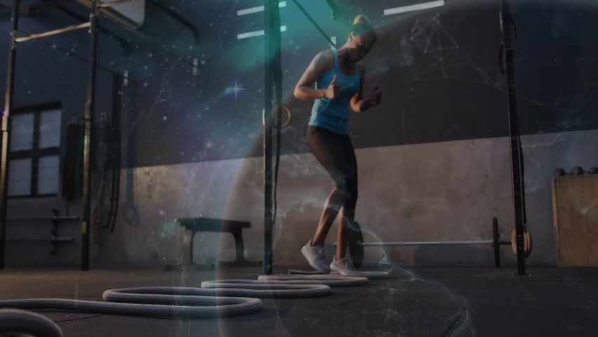 Woman stepping into rings performing two-foot jumps for agility as cosmic overlay energizing gym. Fitness, athleticism, dynamic, modern, strength, training, competition