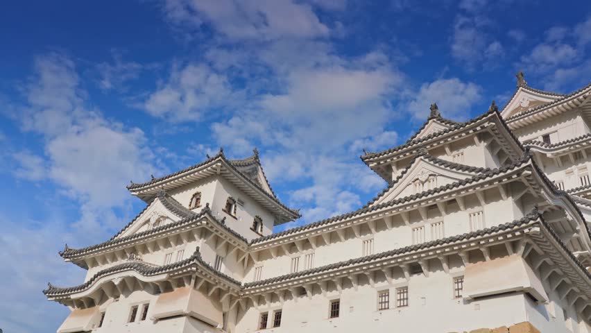 Himeji, Japan - Sep 24 2024, 4k, panoramic view of Himeji Castle, White Heron Castle from behind the roof of the castle outbuildings, in the daytime with blue sky, without people, Himeji, Japan