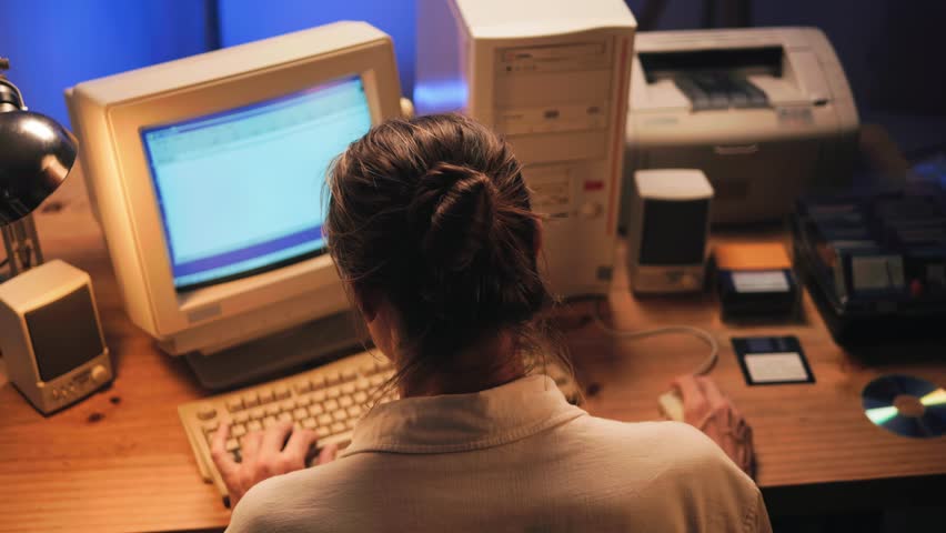Man working and gaming on retro computer PC, IT engineer with vintage computer at home, using old fashion technology, close up of retro setup. 