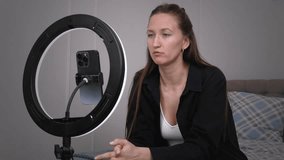 Young woman influencer recording video blog while creating content, using ring light for professional illumination and engaging social media followers from home setting - Powered by Shutterstock - Get 15% off with code: PIKWIZARD15