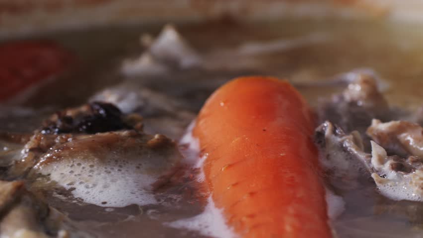Cooking pot with bone broth meat pork and beef, aspic north food. Vegetables cooking ingredients and spices on kitchen table. 