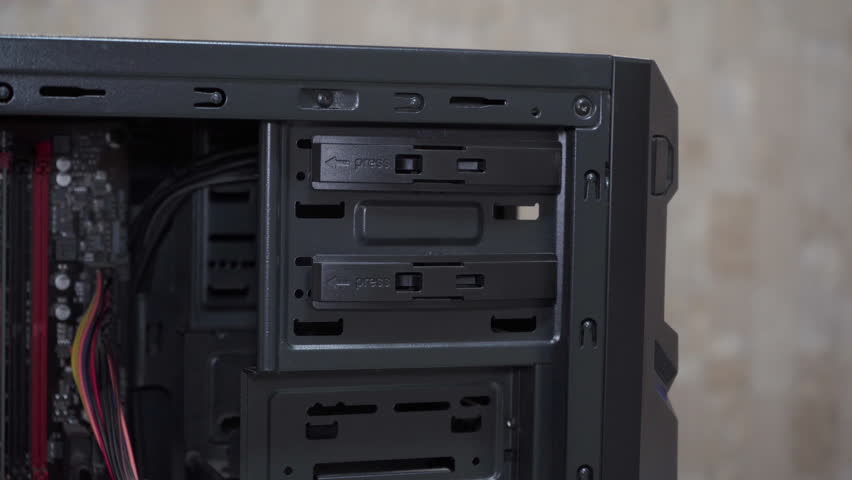 putting an optical drive into a computer, assembling a personal computer, hands install an optical drive into a computer