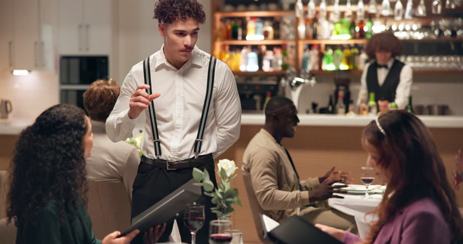 Waiter, customers and women in restaurant, menu and order for food, culinary cuisine and service. People, employee or friends with conversation, fine dining and request with hospitality or decision