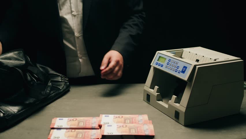 Banknotes and bag counter, Specialised police officer Counting dollar euro banknotes in crime lab with machine, cashed out criminal money, bitcoin changing, buying home flat in bank. 