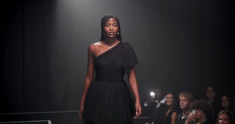 Woman, model and runway with dress for fashion show, garment collection or designer brand. Female person, crowd or audience with clothing line for style, publicity or fashionable trend on walkway