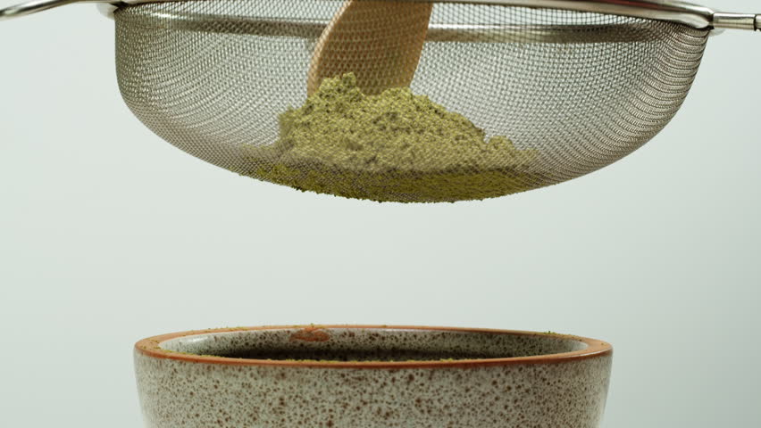 Matcha green tea cooking process, japanese powder green tea in a bowl with bamboo whisk, macro close up in cafe of powder green tea. 