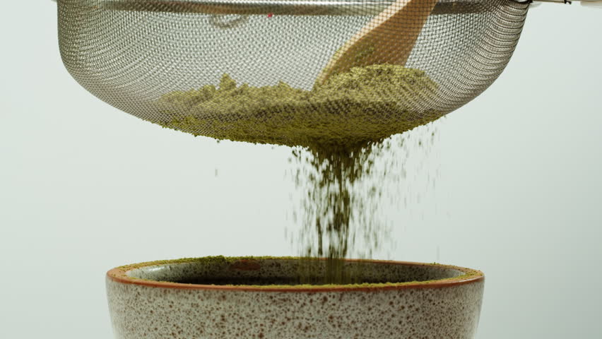 Matcha green tea cooking process, japanese powder green tea in a bowl with bamboo whisk, macro close up in cafe of powder green tea. 