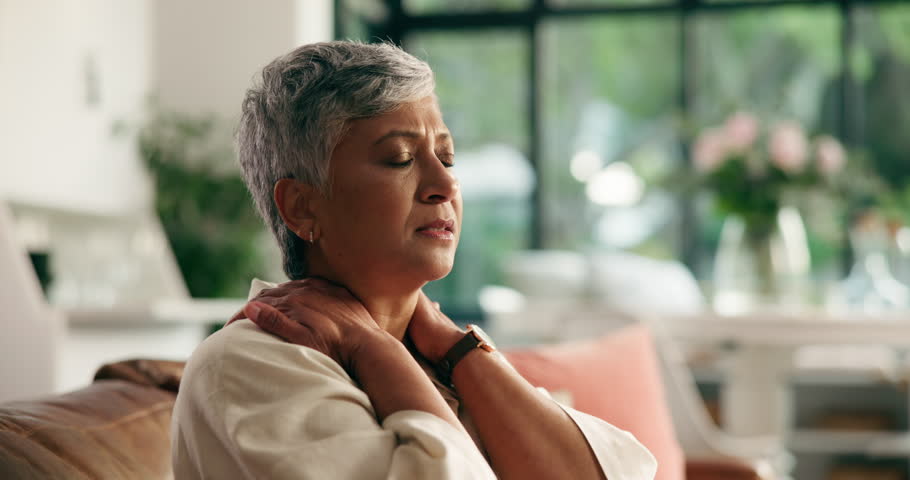 Senior woman, stretching and neck pain on sofa with arthritis, discomfort or muscle sprain. Retirement, old person and massage tension in home for nerve damage, bad posture or osteoporosis from aging