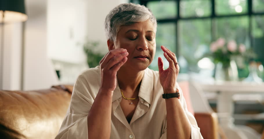 Headache, stress and mature woman on sofa in home with fatigue, tension or brain fog in living room. Burnout, migraine and female person with discomfort for dizziness, exhaustion or vertigo in house.