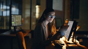 Nighttime investor analyzing blockchain data using touchscreen device in modern workspace closeup. Happy woman focused working at evening hours at home office. Financial trader studying market trends - Powered by Shutterstock - Get 15% off with code: PIKWIZARD15