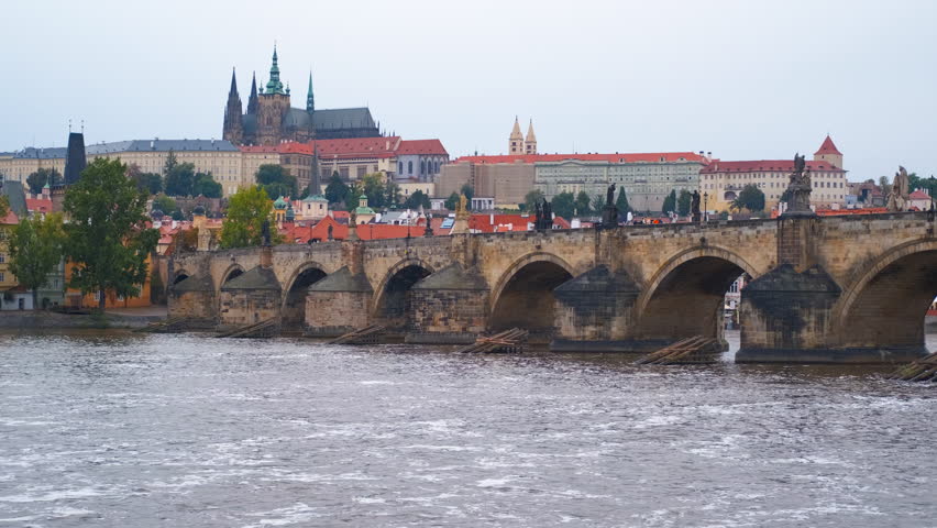 Charles bridge and prague castle. Iconic charles bridge architectural details, ornate statues, prague castle rising against cloudy skyline, revealing historic czech landscape