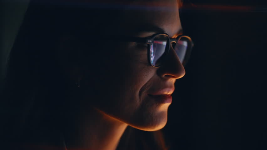 Night woman charts reflection wearing eyeglasses looking computer screen closeup. Smiling crypto trader analyst working with cryptocurrency bitcoin diagrams. Specialist analyzing stock market alone 