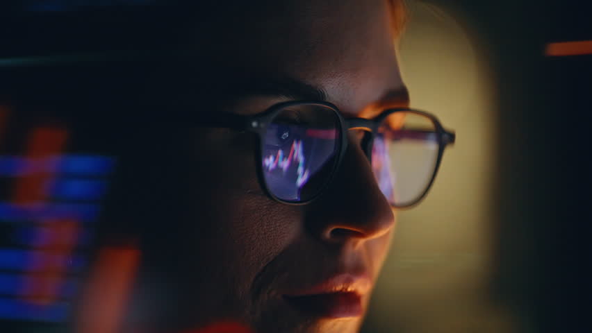 Night worker trades forex at home closeup. Computer screen with stock charts and market analysis reflected in glasses on face. Female analyzing digital big data brainstorming virtual software network 