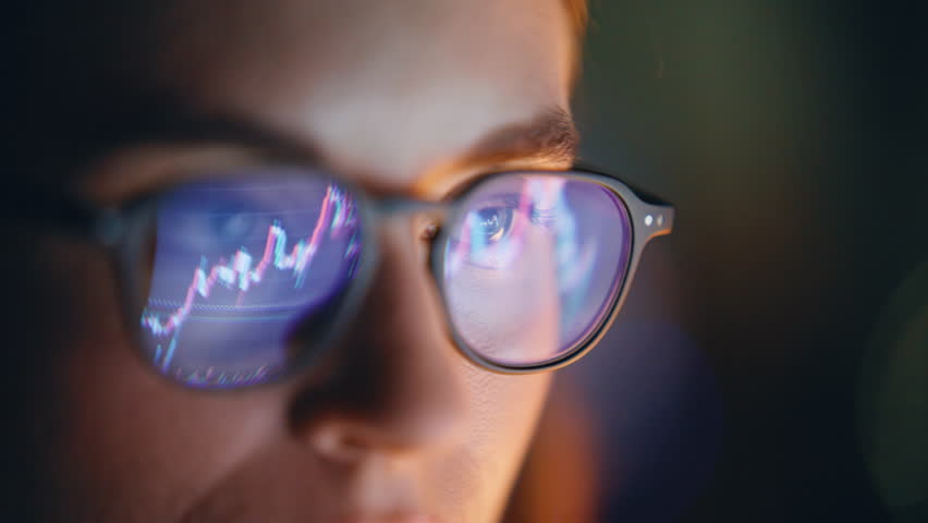 Diagrams woman glasses reflection closeup. Stock market trader face surfing Internet looking growing charts of increasing coins. Specialist analyzing inflation rising prices. Business finance concept