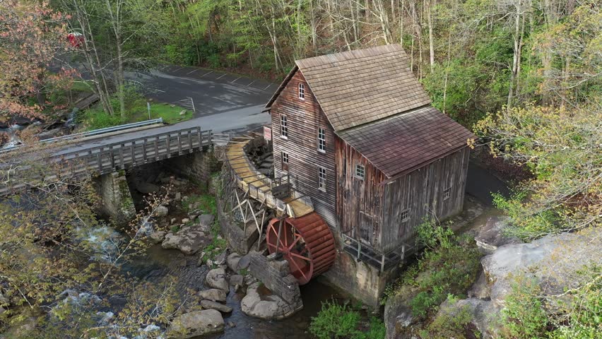Explore the beauty of Babcock State Park in West Virginia, featuring a historic grist mill nestled by a rushing creek and vibrant spring colors.