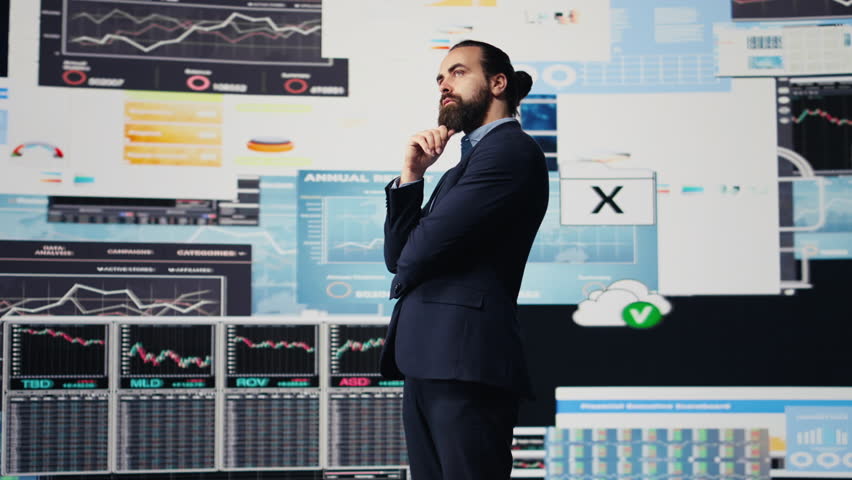 Businessman thinking about a new solution to increase funding while he evaluates infographics and financial reports with digital technology. Planning long term success and growth. Camera B. - Powered by Shutterstock - Get 15% off with code: PIKWIZARD15