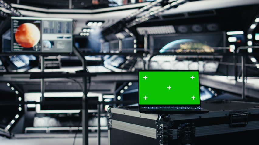 Mockup laptop in orbital station surrounded by high tech displays tracking Mars telemetry. Green screen notebook enabling real time mission control and spacecraft status updates