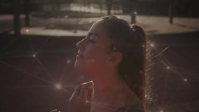 Woman pulling wired earbud into ear, adjusting fit on outdoor court with network overlay for audio. Athletic, technology, nature, fitness, digital, activewear, urban - Powered by Shutterstock - Get 15% off with code: PIKWIZARD15