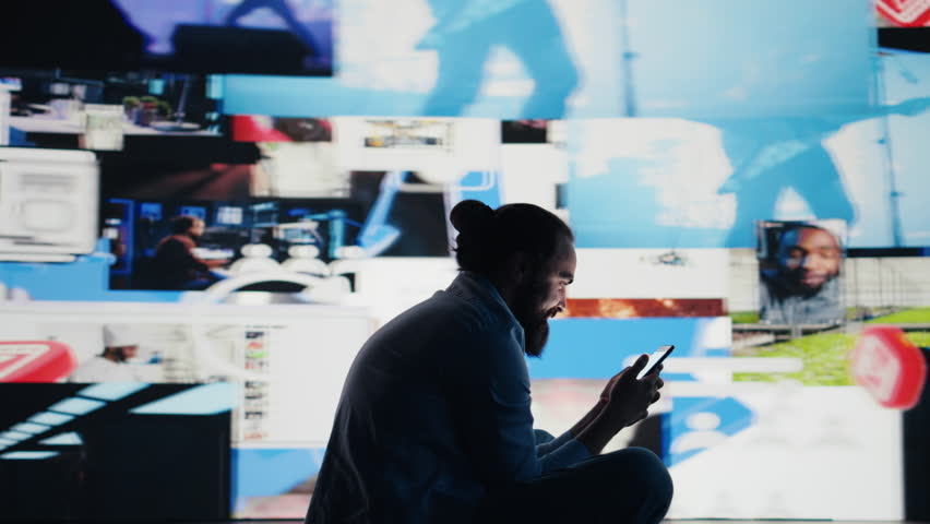 Stressed individual obsessively overuses his mobile phone social apps, illustrating the mental health crisis driven by addiction and excessive information. Cyberbullying and manipulation. Camera B.