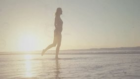 Woman walking into sunlit waves activating digital overlay and kicking water illustrating network. Seaside, silhouette, technology, connectivity, leisure, coastal, vibrant - Powered by Shutterstock - Get 15% off with code: PIKWIZARD15