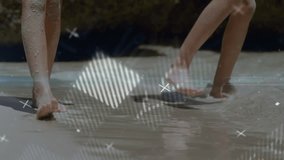 Girls lifting feet and creating data overlays while stepping through surf in beach tech scene. Beach, shoreline, waves, ripples, ocean, sand, water - Powered by Shutterstock - Get 15% off with code: PIKWIZARD15