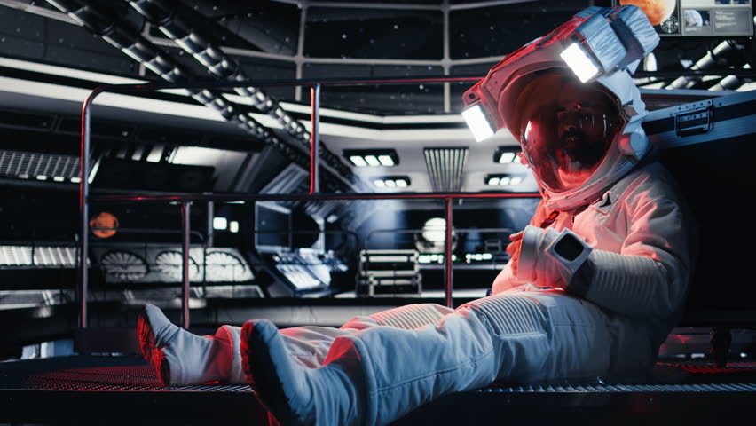 Astronaut pressing wrist display to send SOS signal after onboard incident triggers critical alert. Injured space station crew member attempts to contact ground control during emergency, camera A