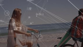 Technology overlay fading in, woman and man pedaling teal bikes along shoreline tracking motion. Adventure, leisure, coastal, recreation, minimalist, vibrant, connection - Powered by Shutterstock - Get 15% off with code: PIKWIZARD15