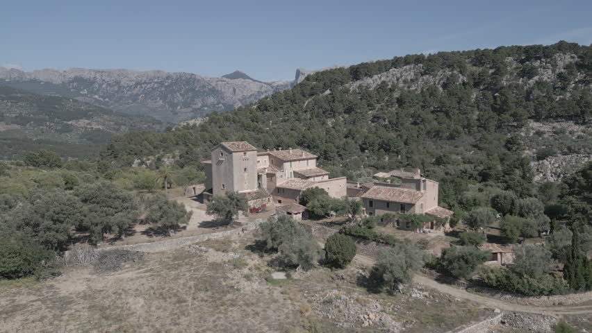 Stunning 4K drone footage over Muleta Gran Hotel in Mallorca, revealing a peaceful hilltop retreat surrounded by mountains, olive groves, and sea views—ideal for luxury, travel, and nature visuals.