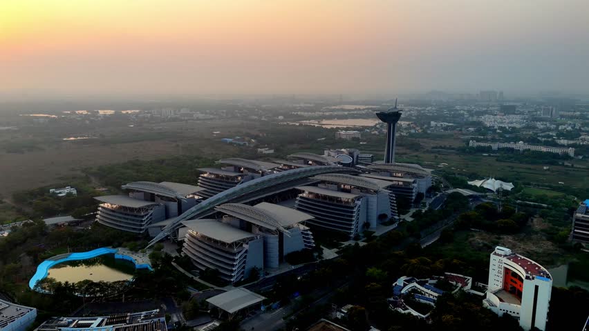 High-angle aerial view of a modern IT park or corporate campus, TCS Siruseri or a similar technology hub in Siruseri SIPCOT, Chennai, India. The prominent contemporary buildings