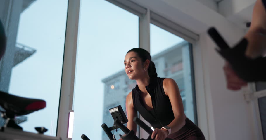 Stationary bike, people and woman in gym, training and cardio with body workout, energy or fitness. Person, group or athlete in wellness center, exercise machine or challenge with health or endurance