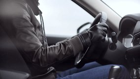 Man in leather jacket and gloves driving a modern car, holding the steering wheel with both hands. Concept of winter driving, road safety, and stylish driver during cold weather. - Powered by Shutterstock - Get 15% off with code: PIKWIZARD15