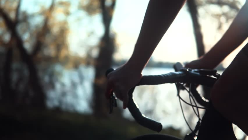 cyclist riding on road bike. cyclist holding handlebars of a racing bike during outdoor cycling session. The cyclist is enjoying nature and cycling along a scenic trail. Cycling bike active lifestyle