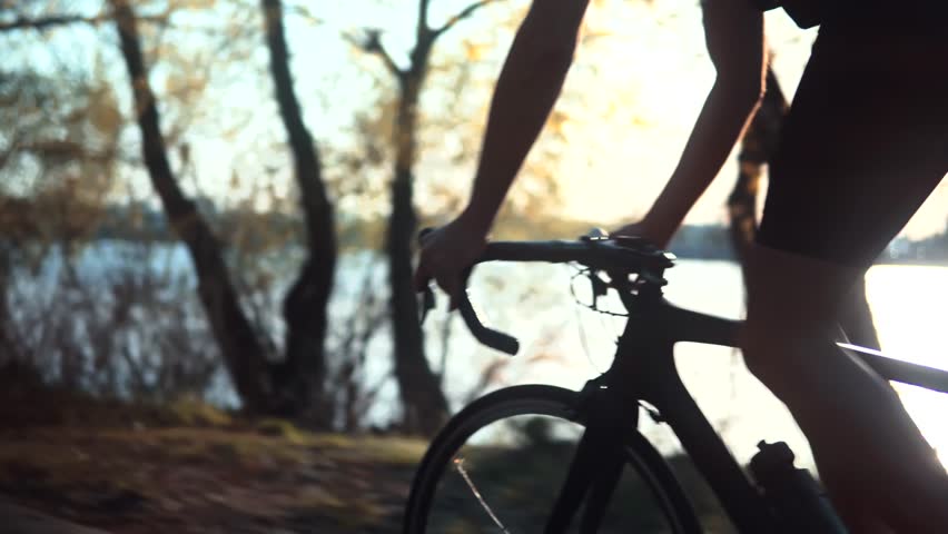 cyclist riding on road bike. cyclist holding handlebars of a racing bike during outdoor cycling session. The cyclist is enjoying nature and cycling along a scenic trail. Cycling bike active lifestyle