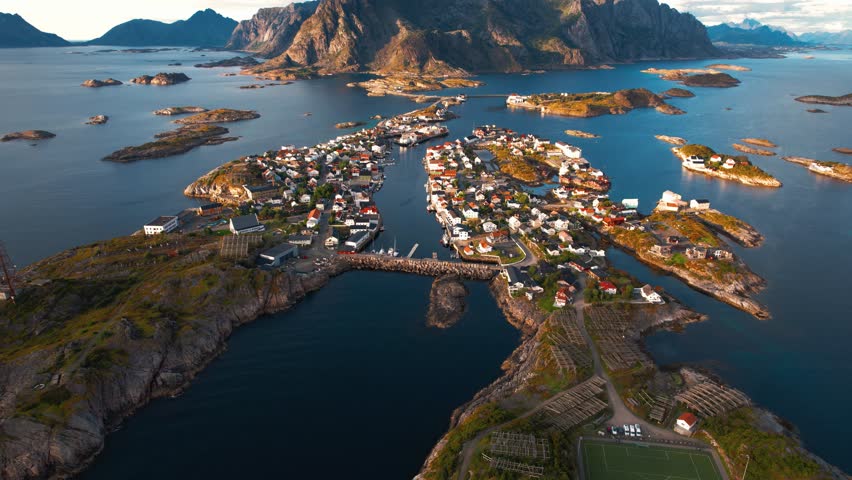 Henningsvaer village on islands, seaside homes, and the iconic football pitch near mountains. Lofoten, Norway.