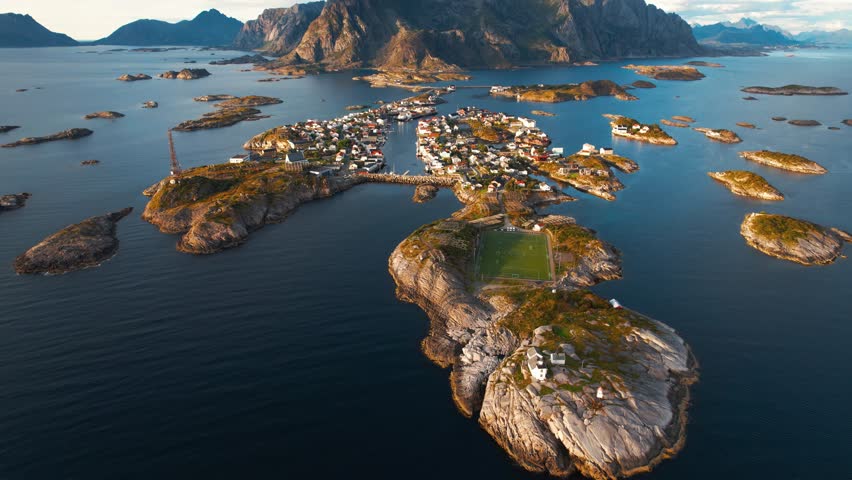 Coastal town Henningsvær with famous soccer field, seen from above in dramatic Lofoten region, Norway.