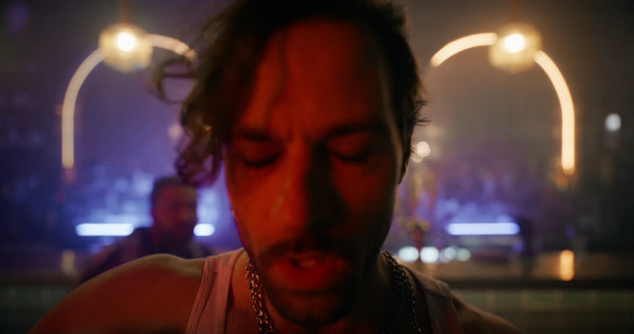 Drunk Flamboyant Man Walking on a Dancefloor, Drinking Shots, Making Out and Kissing a Hedonistic Female in the Middle of a Diverse Party Crowd. Joyful Hysterical Young Male Sitting Down to Rest