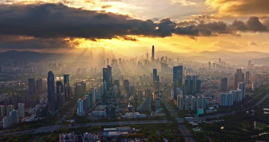Aerial shot of modern city commercial buildings with dramatic skyline at sunrise in Shenzhen, China.