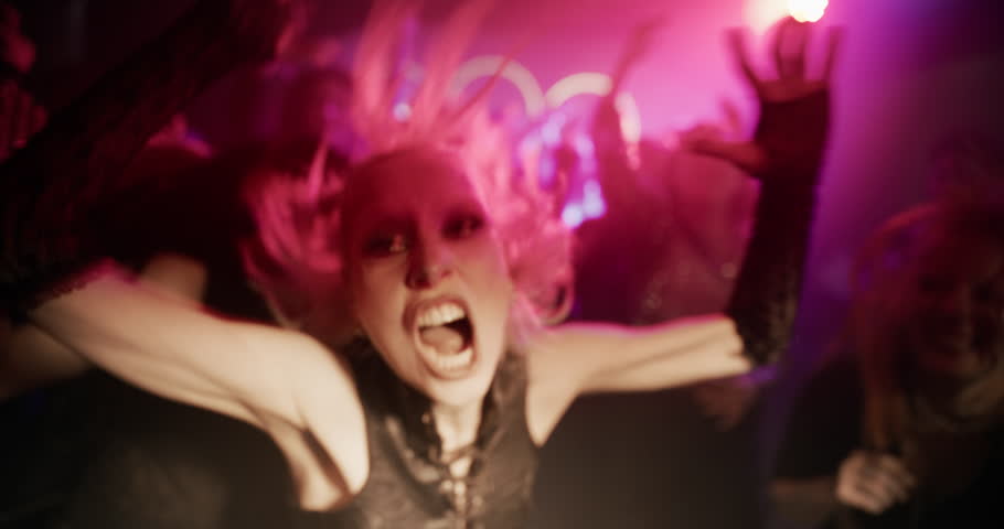 Close Up Portrait of a Blonde Young Woman Dancing Wildly in a Nightclub. Her Intense Gestures and Expression, Aggressive Moves Capture the Raw Energy of Nightlife Euphoria, Hedonism, Craziness