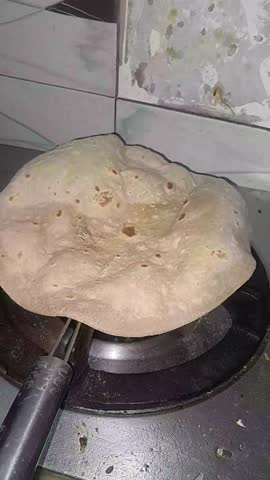 A girl making roti on gas
