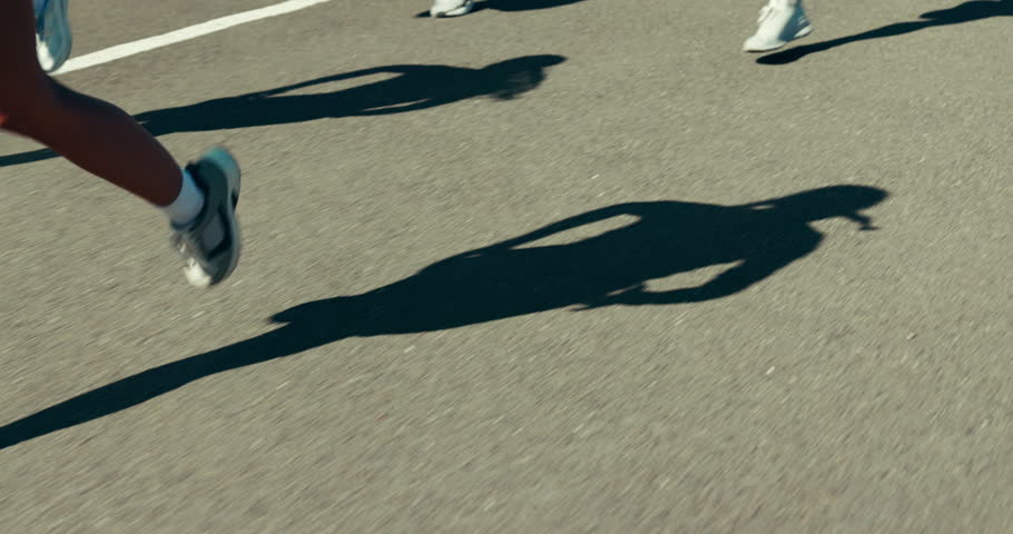 Legs, runner and group in street for fitness, challenge and training with speed, shadow or workout. People, feet and shoes for sports, outdoor and fast on urban road with exercise club in city