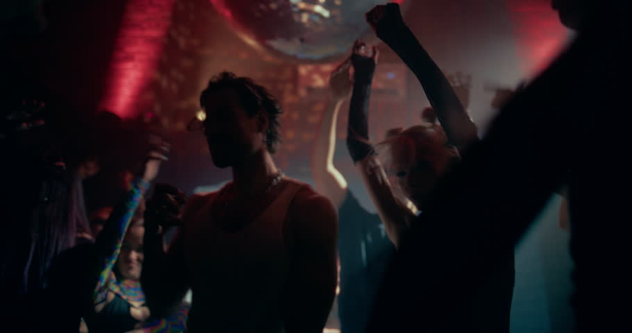 Slow Motion Footage of a Crowded Modern Nightclub with Diverse Beautiful People Dancing to Dynamic Electronic Music. Lights Pulse in Sync with the Beat. Ecstatic, Youthful and Hedonistic Mood