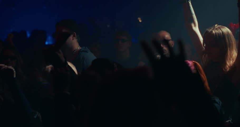 Creative People Move to Energetic Techno Rhythms in a Dark, Color-Drenched Club with Flashing Stroboscopes. Cinematic Slow Motion Footage Celebrating Nightlife, Youth Culture, Freedom and Urban Energy