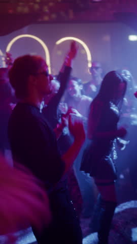 Vertical Screen: Diverse Party Crowd Enjoying Time in an Underground Nightclub, Dancing Energetically Under Pulsating Lights and Inspiring Music. Young Men and Women Having an Emotional Night Out