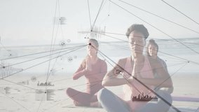 Four women on beach mats practicing yoga syncing breath and prayer upon HUD overlays fading in. Wellness, mindfulness, serenity, digital interface, group exercise, tranquil, nature - Powered by Shutterstock - Get 15% off with code: PIKWIZARD15