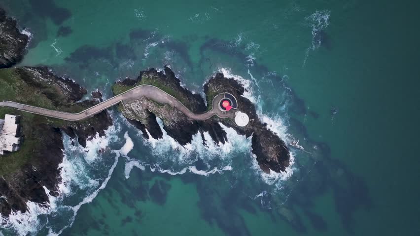 Aerial view of le petit minou lighthouse on rugged cliffs with crashing waves and a picturesque coastline, Plouzane, Finistere, France.