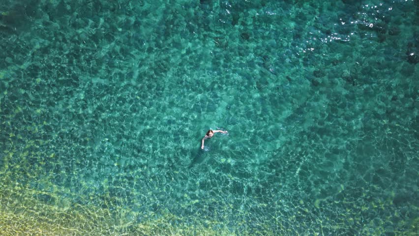 Top down view Young Woman Enjoying Seaside Vacation in Neos Marmaras Greece Relaxing Travel Moment in Summer Paradise